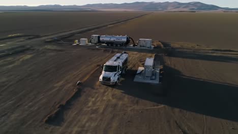 aerial view of an industrial truck and fueling station in a vast desert landscape, reflecting operational efficiency and remote logistics solutions