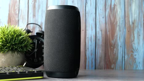 black cylinder portable bluetooth speaker on a desk