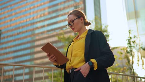 Businesswoman-working-on-digital-tablet-standing-at-terrace