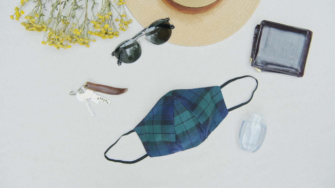 Top down view of manly personal items, coronavirus era essentials flat lay, concept of items a person will carry around. mandatory face mask for safety, pan right