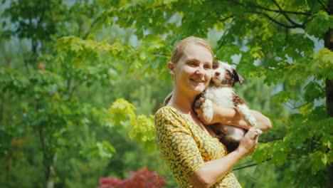 Happy-Middle-Aged-Woman-Cuddles-Wet-Puppy-They-Stand-In-The-Garden-In-The-Rain-Unforgettable-Moments