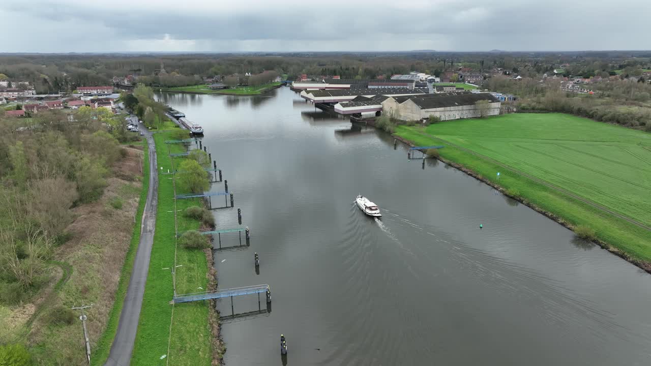 The Luxemotor Boat moving along the canal in Strepy Thieu during a semi orbit shot on a cloudy day