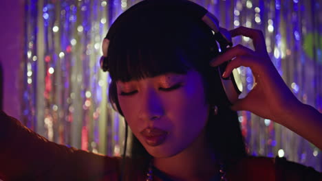 relaxed dj headphones dancing fine-tuning music at trendy nightclub closeup