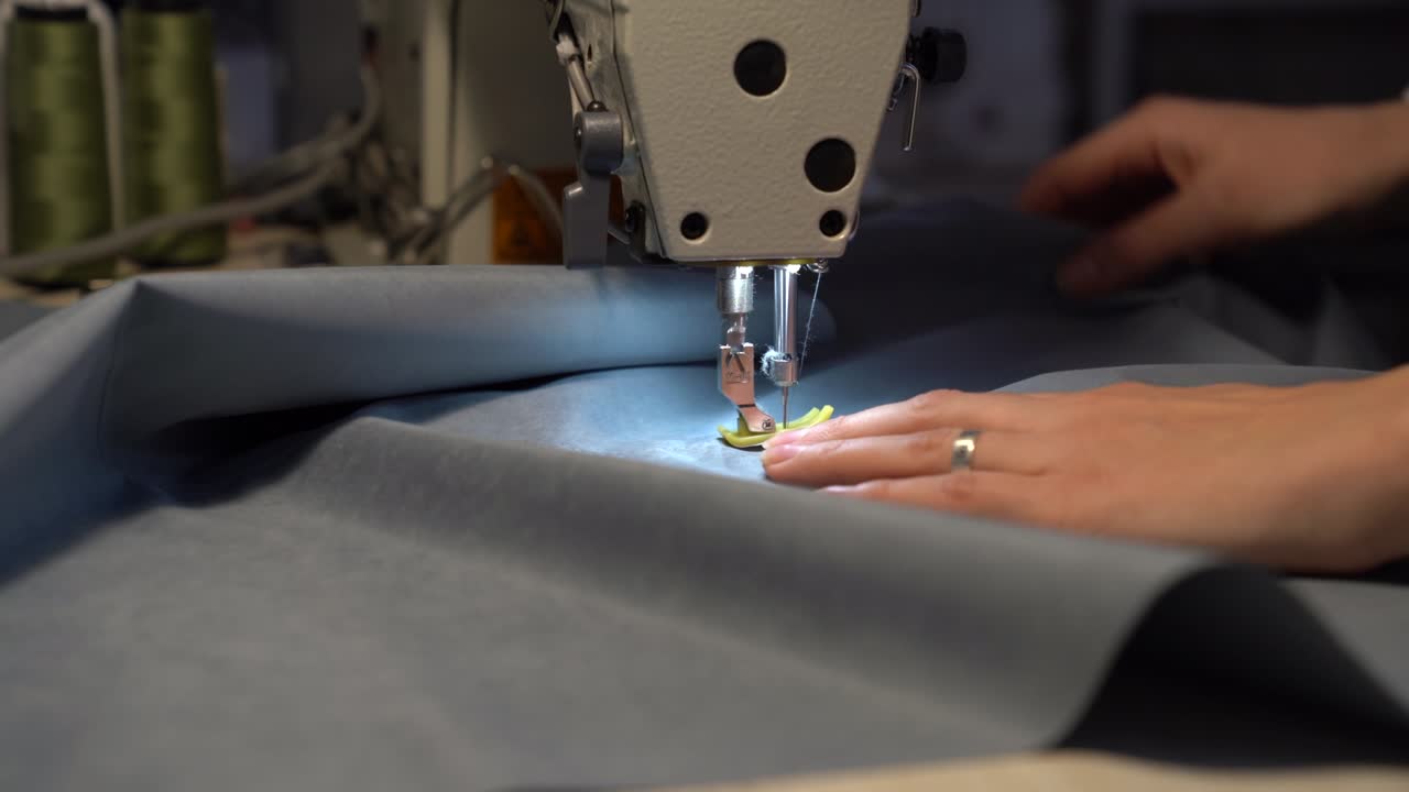 Seamstress work on sewing machine, closeup. Woman fashion designer create new clothes collection