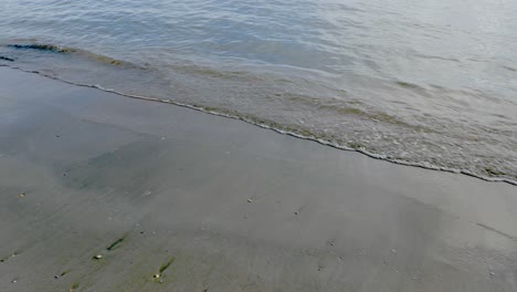 Soft-sea-waves-splashing-on-a-sandy-golden-colored-beach