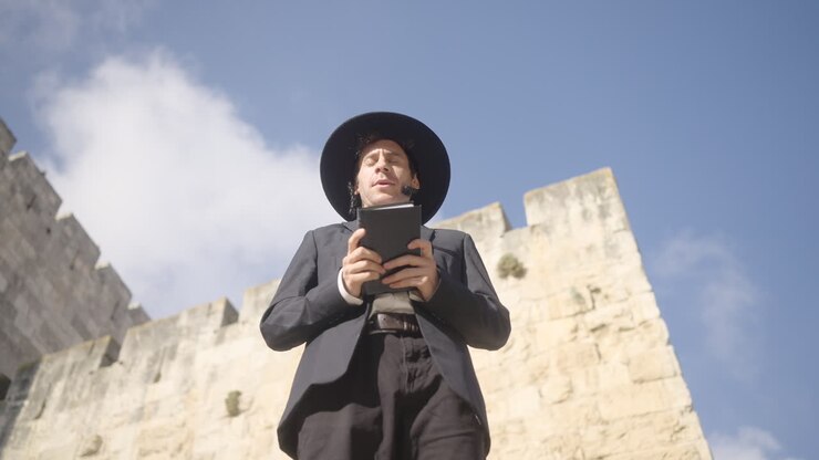 Uomo ebreo ortodosso che prega con in mano la Torah (Bibbia ebraica) a Gerusalemme, Israele