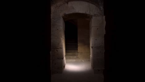 pasa a través de un largo y oscuro sótano romano. sótano debajo del anfiteatro en el jem, tunis. antiguo edificio romano. la cámara se acerca