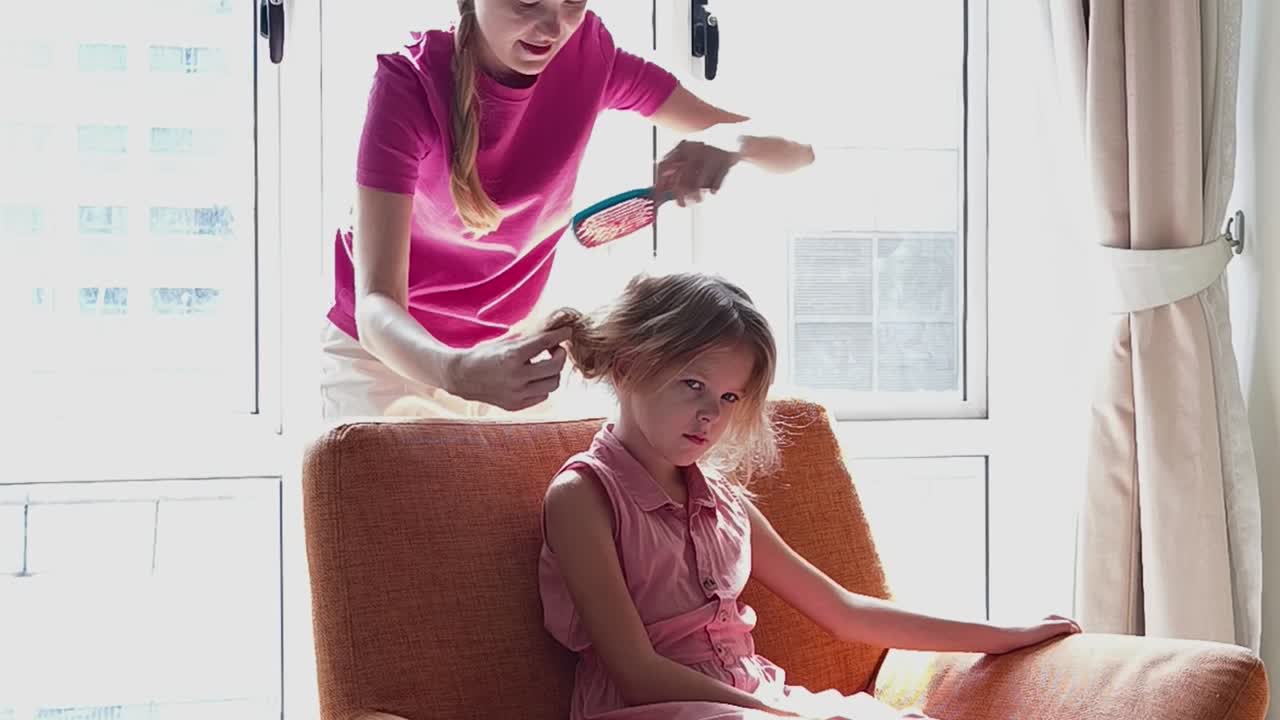 Mother brushing daughter's hair