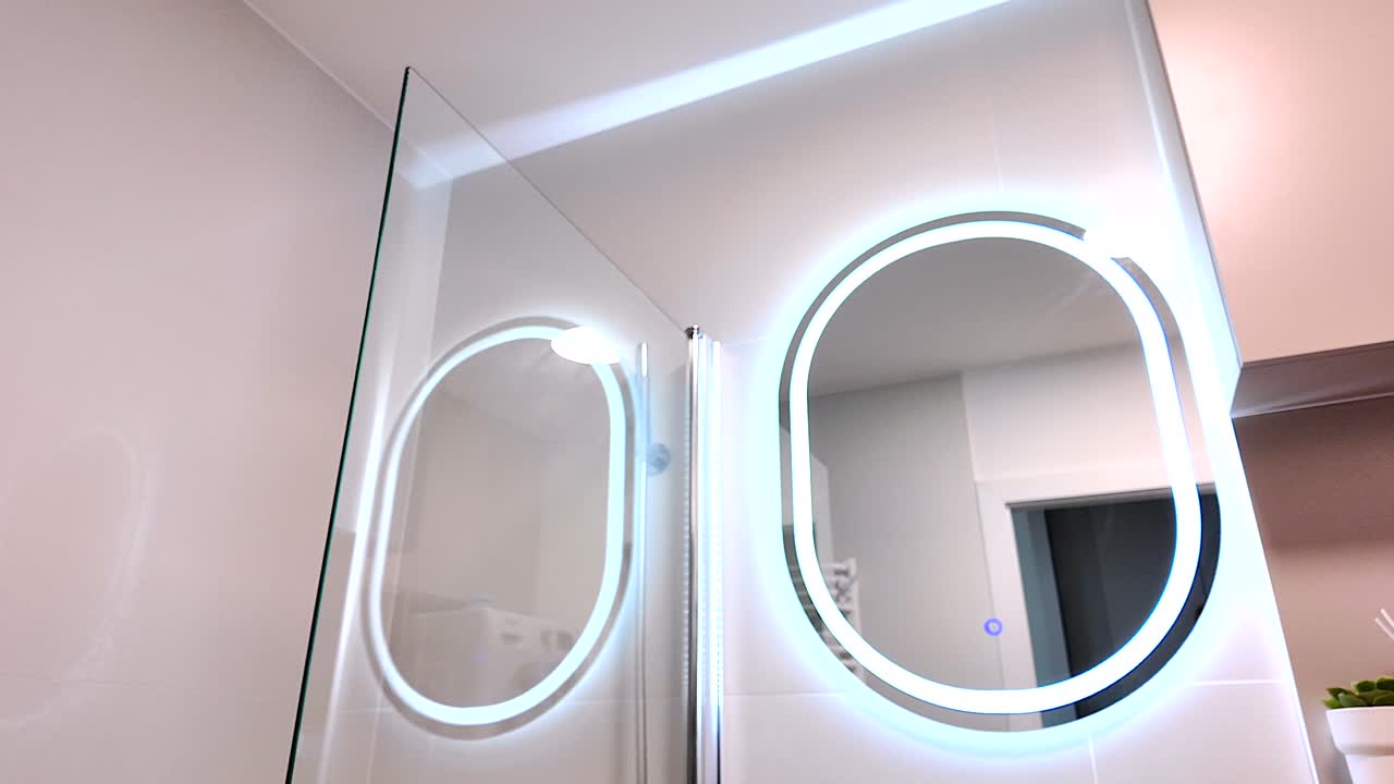 espejo iluminado moderno en un baño pequeño y práctico, bienes raíces