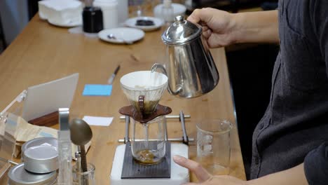 close up shot of man pouring hot water to make third wave coffee at café in taipei, taiwan
