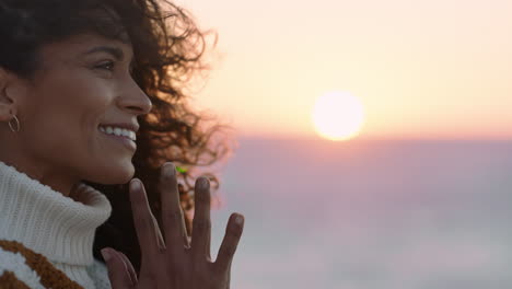 portrait of beautiful hispanic woman enjoying peaceful seaside at sunset exploring mindfulness contemplating spirituality with wind blowing hair