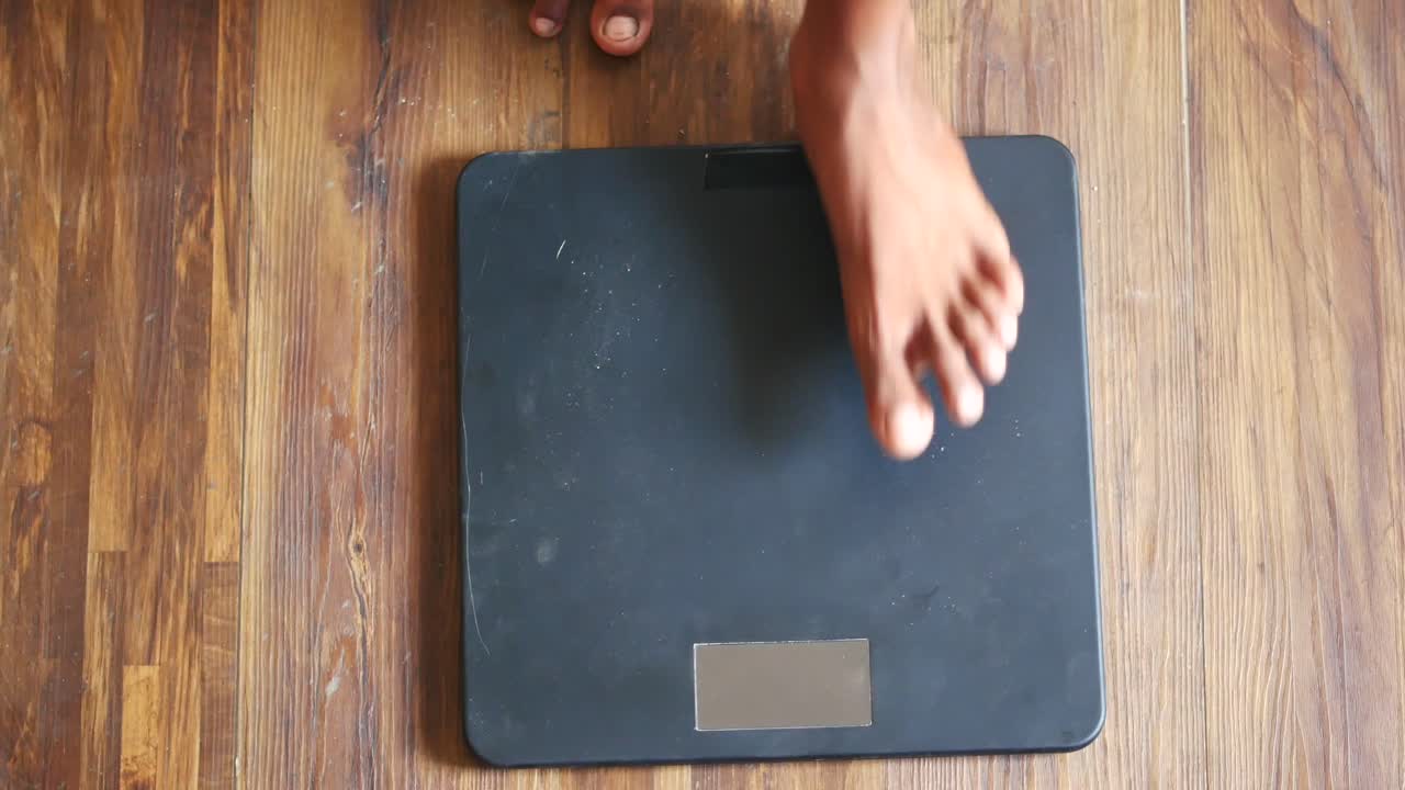 Person Weighing Themselves on a Scale
