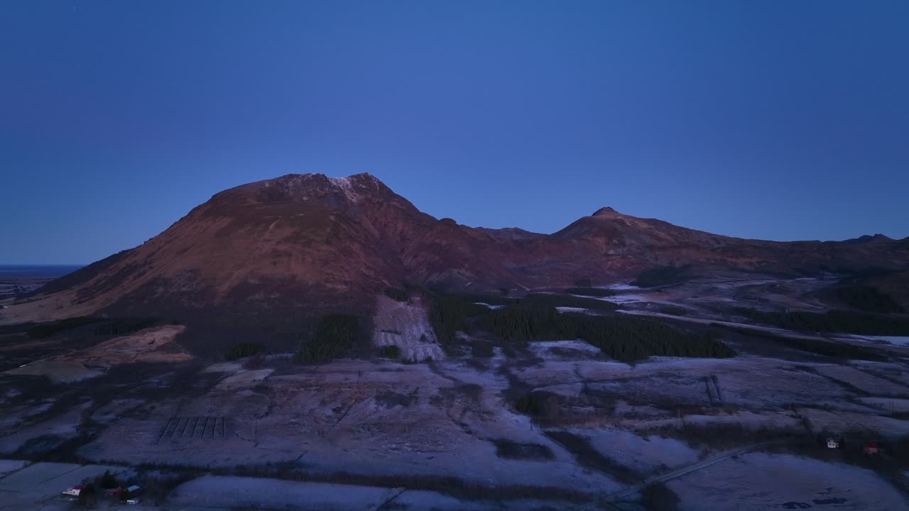 Aerial footage of Bleik, Andøya, showcasing steep cliffs, fjords, and the ocean during golden hour. Capturing the serene beauty of Arctic landscapes with vibrant sunset hues.