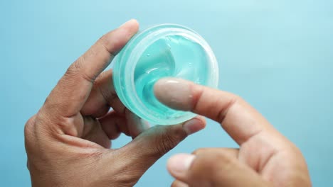 la mano sostiene un frasco de gel para el cabello