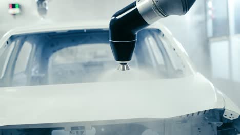 robotic arms spray painting a vehicle body at a car manufacturing factory