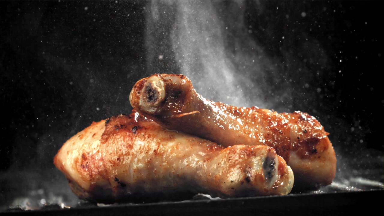 Deliziosi Fusi di Pollo alla Griglia Fumanti su Sfondo Scuro