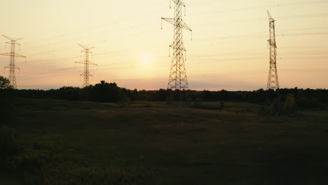 Sobrevuelo-Aéreo-De-La-Silueta-De-Las-Líneas-Eléctricas-De-Transmisión-De-Alto-Voltaje-En-El-Campo-Rural