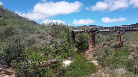 un viejo puente abandonado cruza el río en las colinas áridas-2