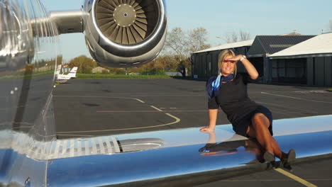 slomo: a playful flight attendant sits on the wing of an aircraft