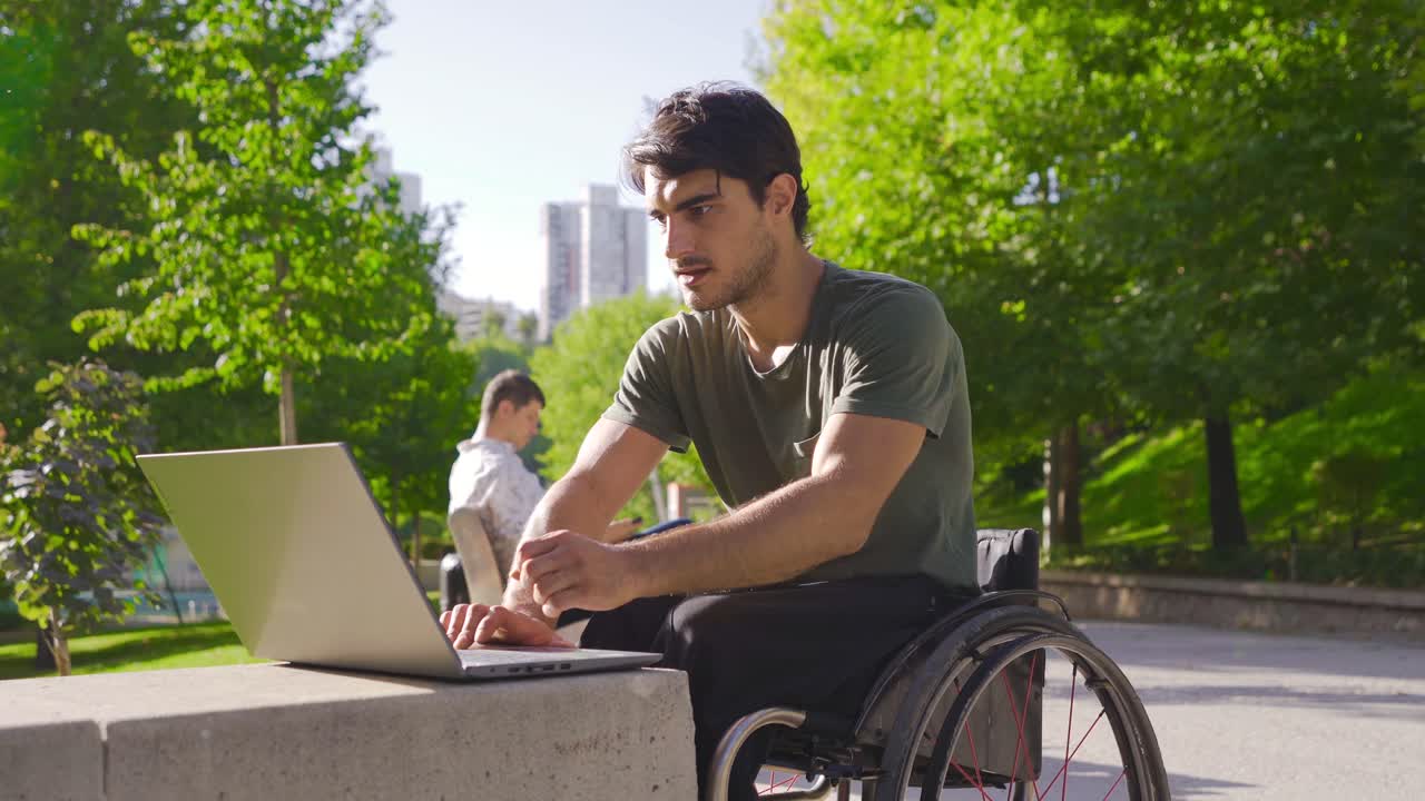 jóvenes con discapacidad física trabajando con una computadora portátil al aire libre.