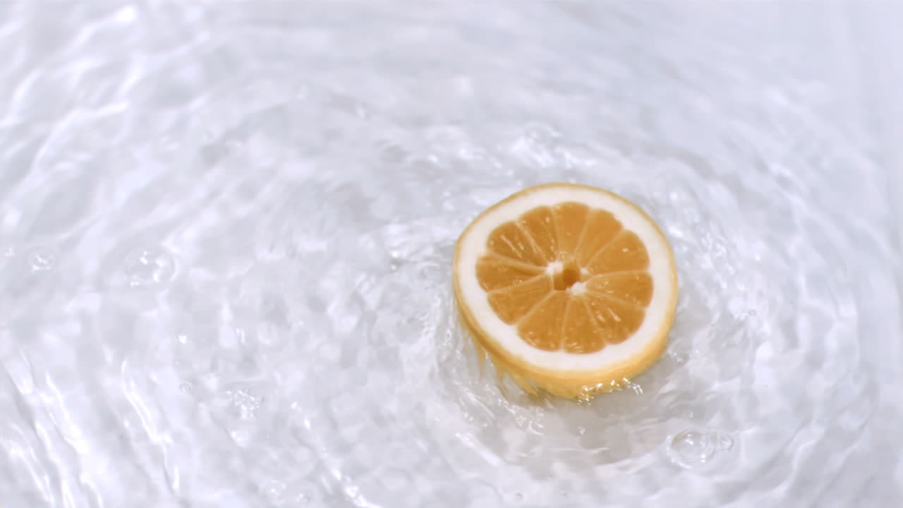 Arancia che ruota nell'acqua in super slow motion