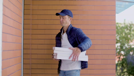 delivery man with pizza knocking on door of customer's house