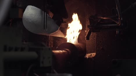 metal foundry pours molten metal with flames