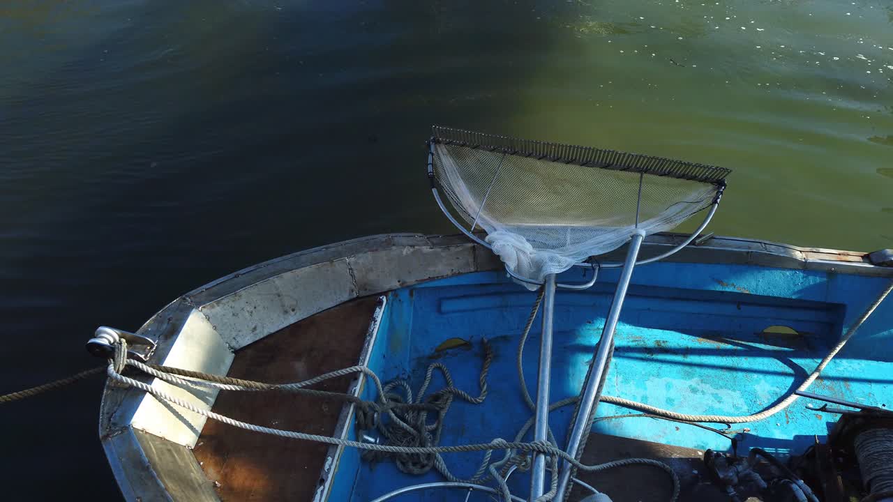 barco de madera flotando en un canal en borghetto dei pescatori en lido di ostia, un distrito de roma a orillas del mar