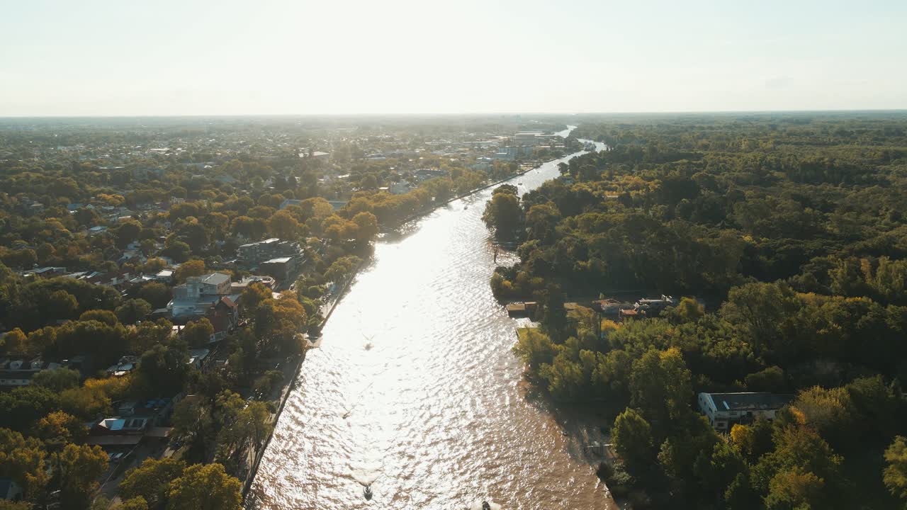 vista aérea del río lujan con casas y árboles a los lados cerca del atardecer