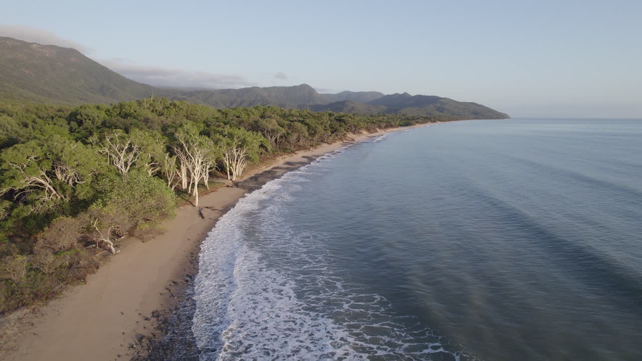 olas espumosas salpicando la orilla de la playa en la playa wangetti en el norte de queensland, australia - toma aérea