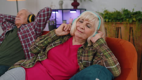 familia feliz ancianos abuelos hombre mujer con auriculares escuchando música relajándose en el sofá en casa