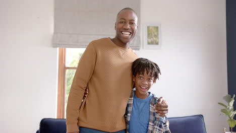 portrait of happy african american father and son embracing at home, slow motion