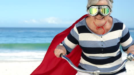 senior caucasian woman seaside wearing a red cape