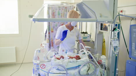 nurse caring for newborn in neonatal intensive care unit
