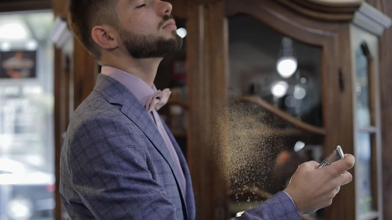 el novio se divide el perfume en sí mismo. día de la boda. cámara lenta