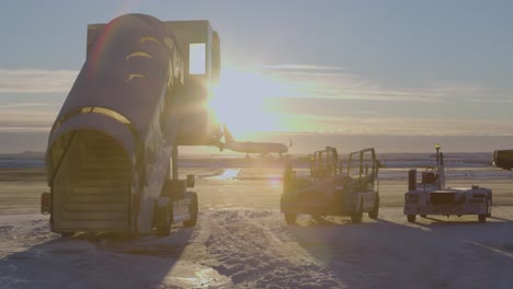 vehículo de coche de escalera parado en el aeropuerto de asfalto nevado con luz solar brillante al atardecer