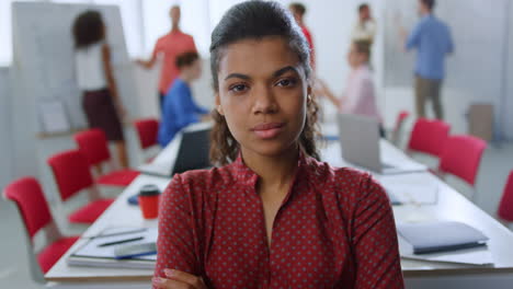 serious afro woman posing camera office. businesswoman standing meeting room