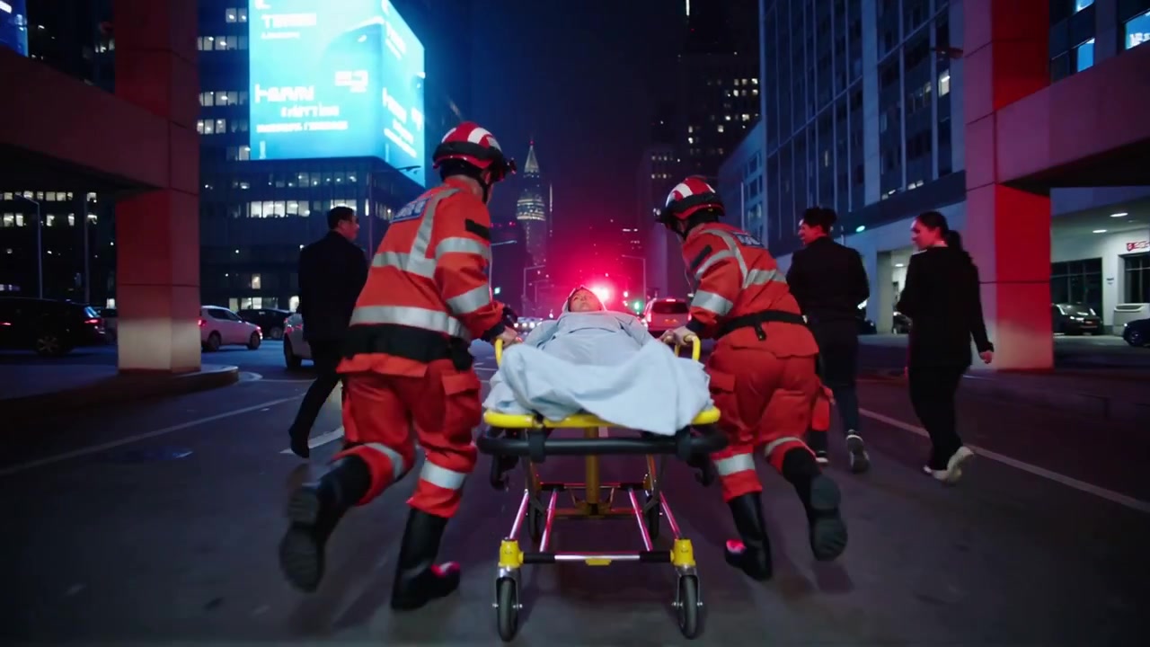 Skubber båre, to røde ambulancefolk skynder sig fra skadestuen ud på gaden, blinkende lys mod ambulance, iltmaske.