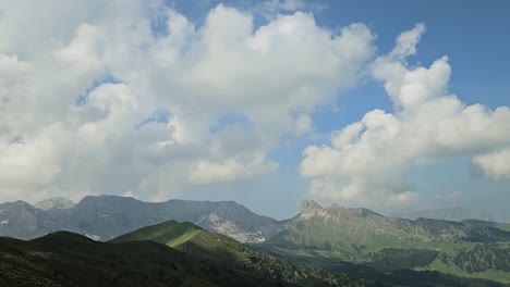 time lapse of white clouds passing by in italian dolomites, casting shadows on the hills below