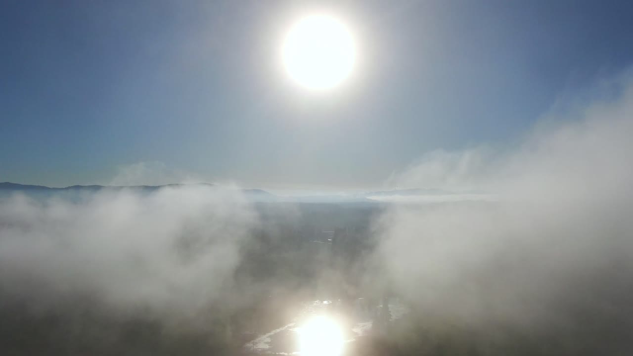 vuelo de drones de 4 km a través de las nubes, volando directamente al sol y al lago en un día brillante