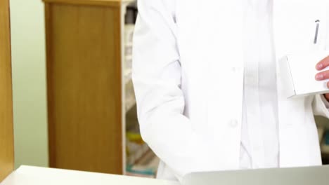 Pharmacist-making-prescription-record-in-laptop