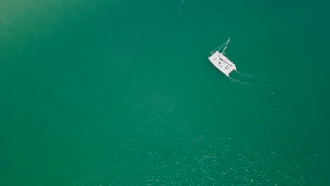 el catamarán hace un giro cerrado a estribor en la antena de una laguna verde intenso