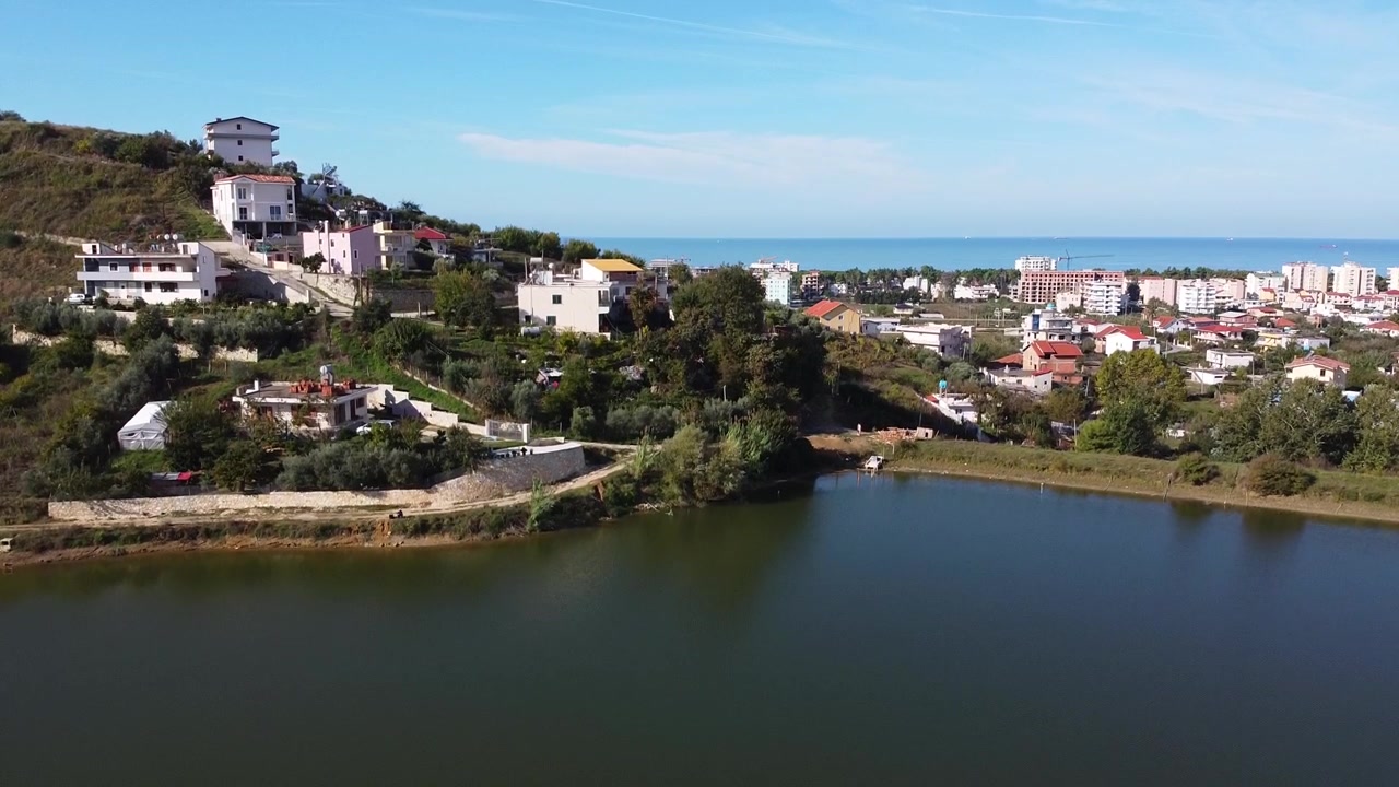 Luftfoto over en liten innsjø nær kystlandsbyen Golem i Albania.