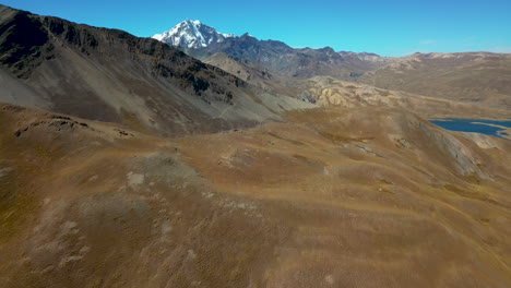 aerial drone view flying over a mountain ridge to reveal a scenic alpine lake in the andes range