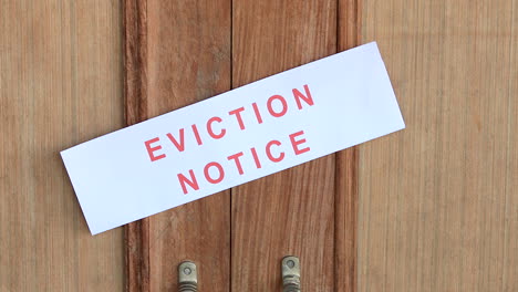 vertican pan of eviction notice sticking on the entrance door of the house