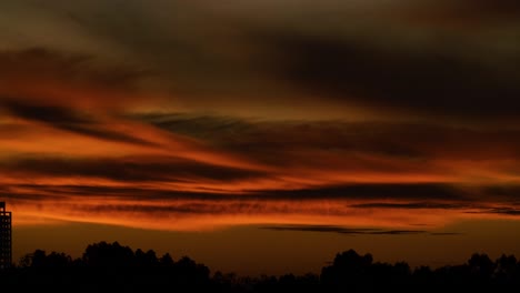 The-fiery-moon-rising-in-the-night-sky-over-the-landscape---time-lapse