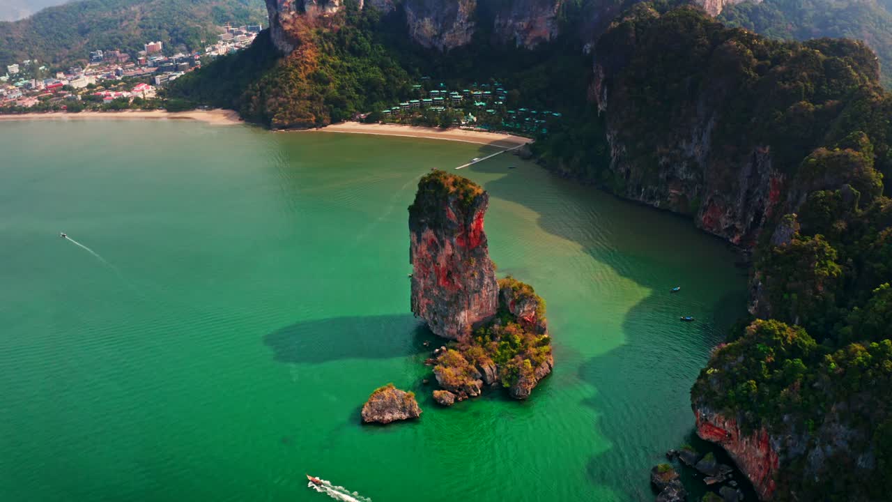 Close-up aerial shot of a towering limestone pillar in Krabi, Thailand. Vivid colors and warm tones enhance the tropical beauty. Ideal for nature, adventure, and tourism content.