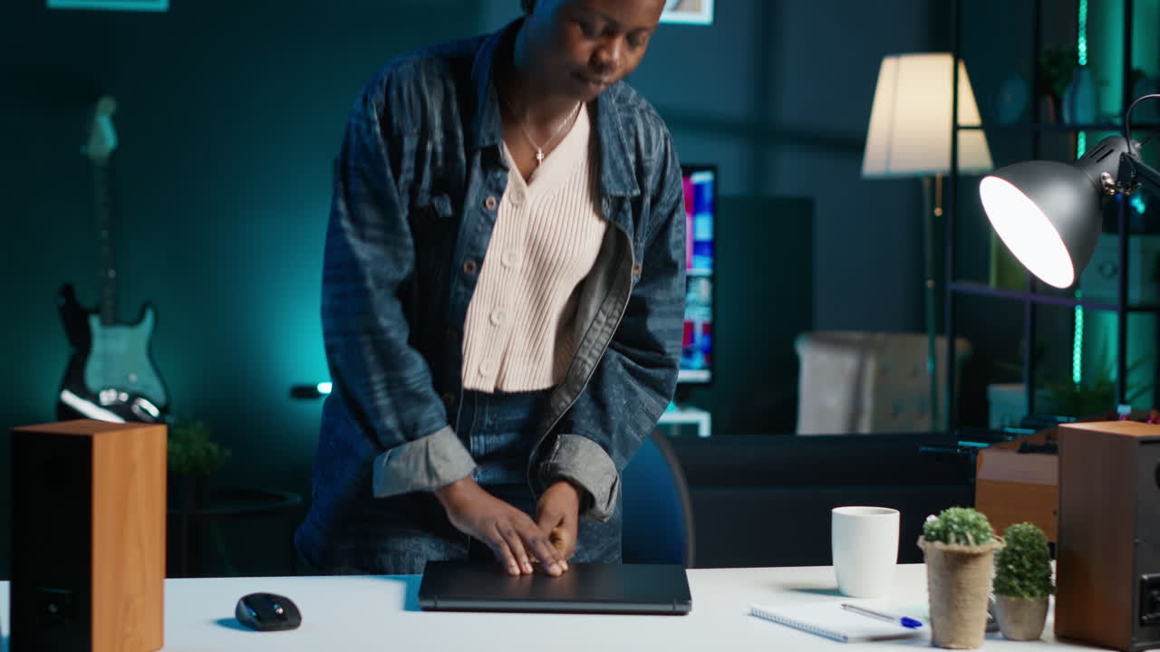 mujer trabajando desde la oficina de casa con una computadora portátil, viendo las noticias en la televisión