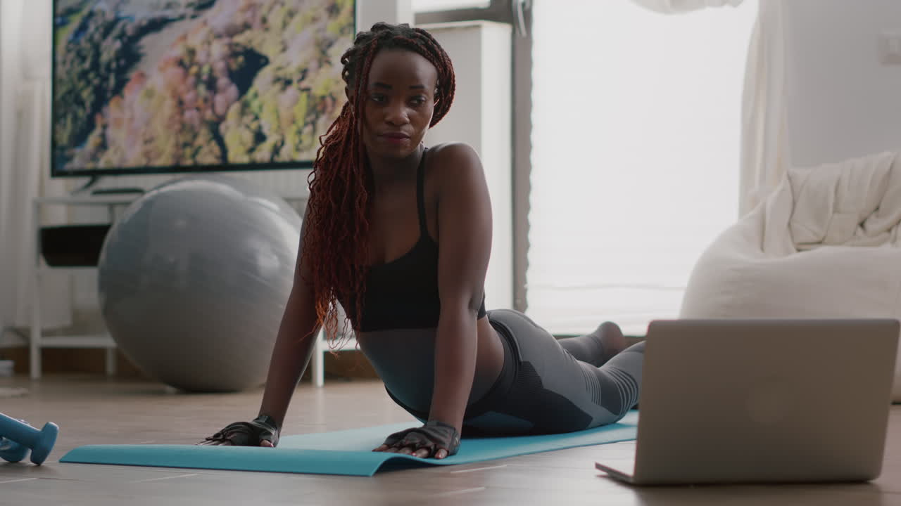 Flexible black woman practicing sport during yoga morning workout