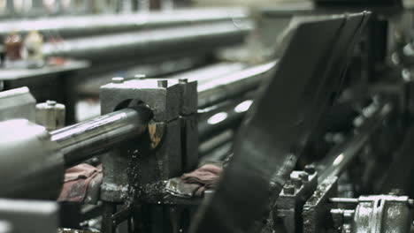 Sliding-shot-of-pipe-honing-machinery-working-in-a-manufacturing-plant-with-steam-plume